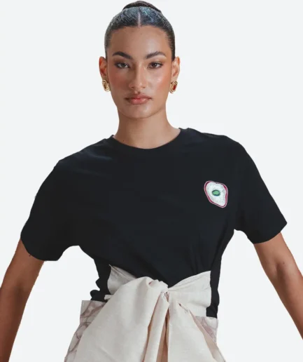 Editorial portrait detail view of the Felix Matos Ajo T-Shirt showing the black T-shirt with garlic-inspired embroidered detail.