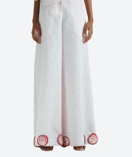 Product detail view of the Felix Matos Huerto Pants featuring pale pink wide-leg pants with circular embroidered appliqués at the hem.