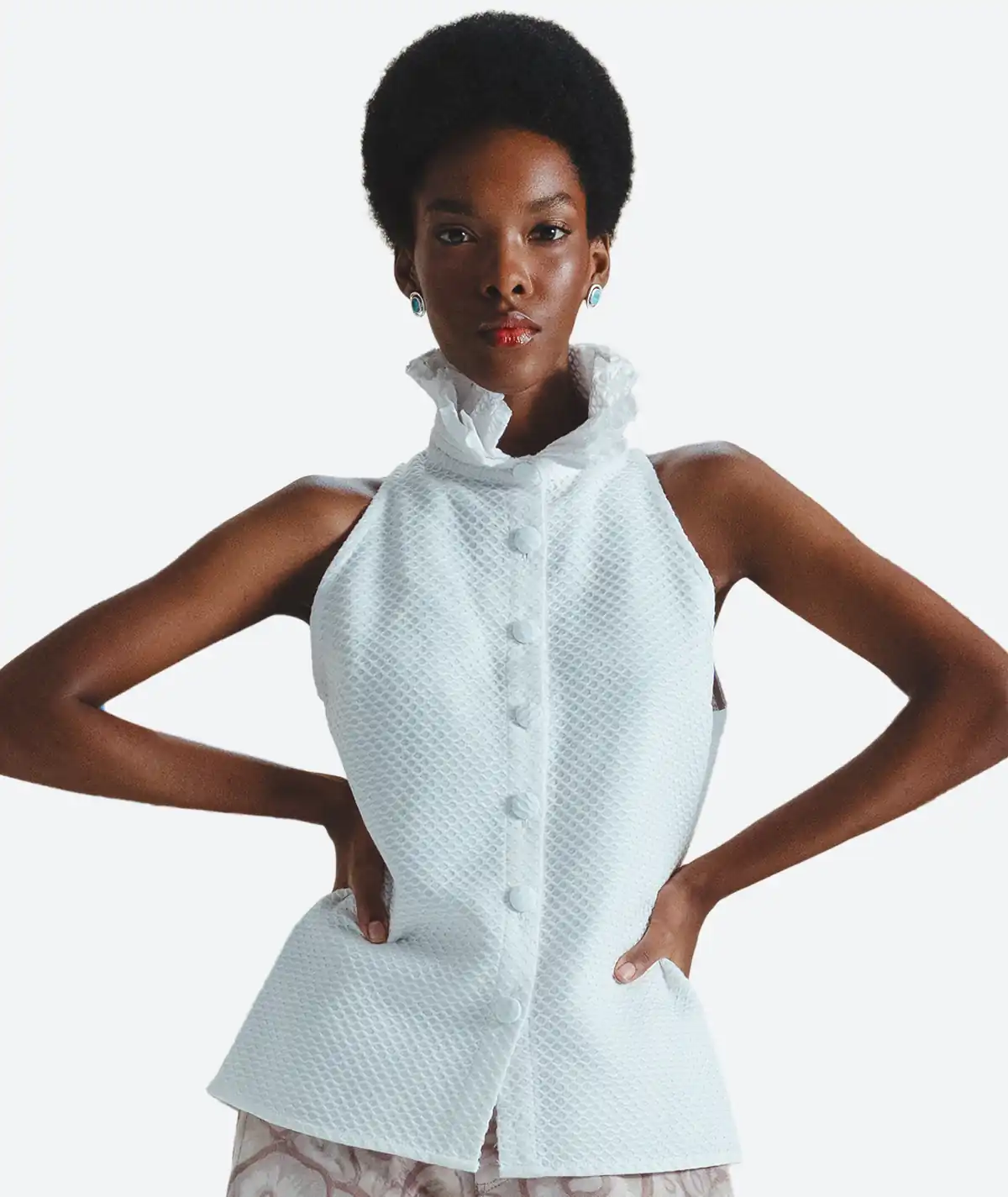 Savia Top – Detail Front View Detail front view of the Felix Matos Savia Top featuring a white sleeveless high-neck silhouette, textured fabric and front button closure.
