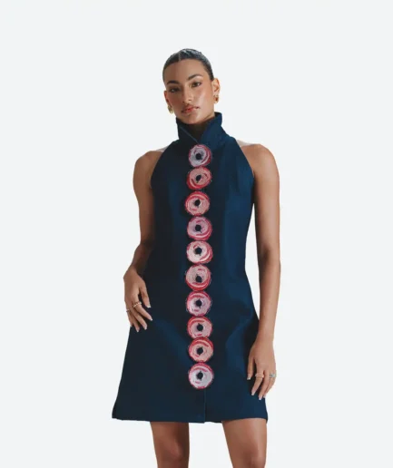 Clean front view of a model wearing the Felix Matos Shallot Dress, a navy sleeveless mini dress with a high neckline and circular embroidered appliqués.