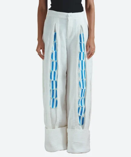 Product detail view of the Felix Matos Soya Pants featuring ivory textured wide-leg pants with blue circular appliqué details and oversized cuffs.