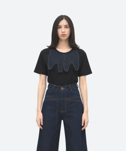 Product detail view from the Felix Matos Commune Collection featuring a black T-shirt with a dark denim collar appliqué and high-waisted denim pants.