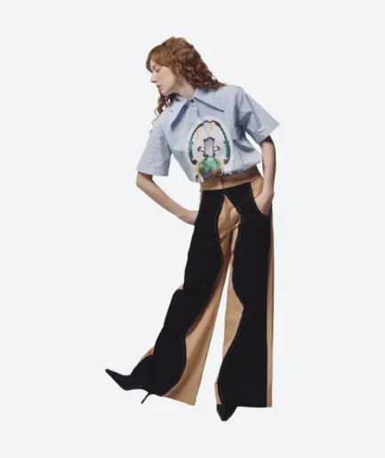 Product look front view from the Felix Matos Commune Collection featuring a blue striped bug shirt with black and tan wide-leg pants.