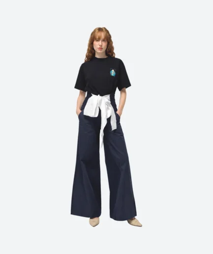 Product look front view from the Felix Matos Commune Collection featuring a black T-shirt with embroidered chest detail, navy wide-leg pants and a white front tie accent.