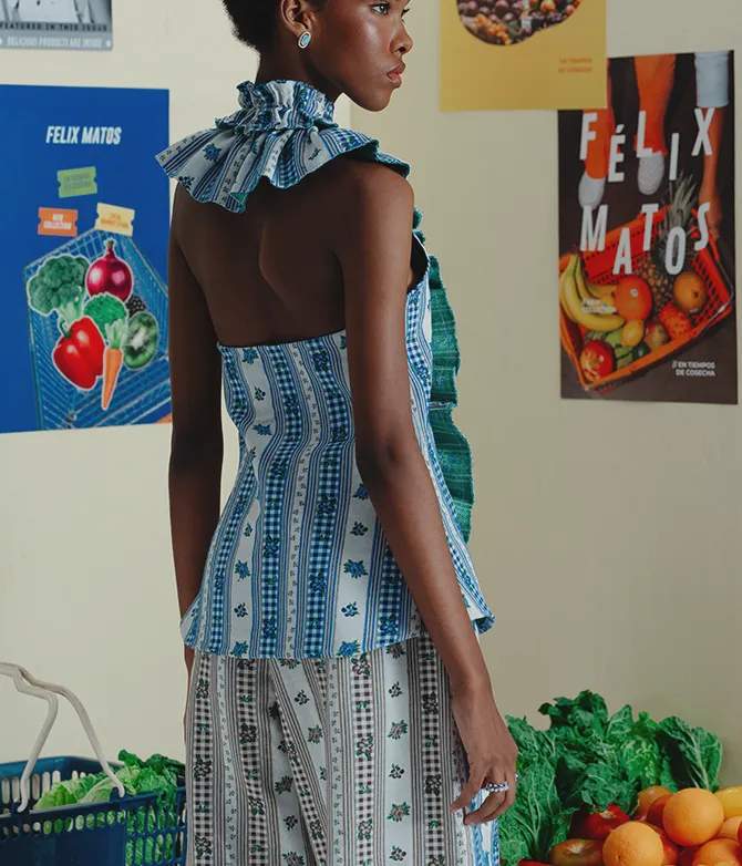 Model shown from the back wearing a blue printed Felix Matos look in a featured collection campaign setting.