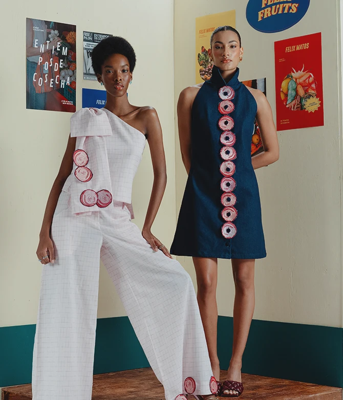 Two models wearing Felix Matos featured collection looks, including a pale one-shoulder outfit and a navy dress with circular appliqué details.