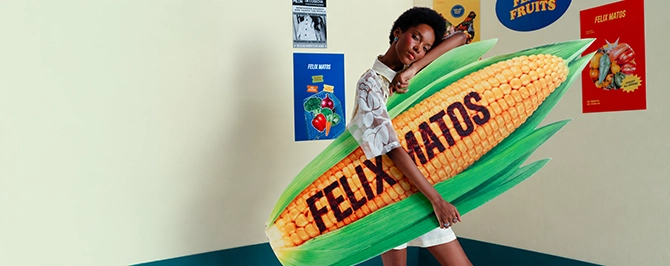 Model wearing a green striped shirt with a ladybug appliqué and dark pants from the Felix Matos Commune collection.